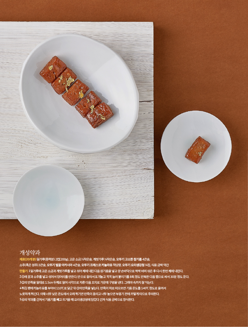 개성약과
재료(20개분) 밀가루(중력분) 2컵(200g), 고운 소금 ½작은술, 계핏가루 ⅓작은술, 오뚜기 고소한 참기름 4큰술, 소주(혹은 청주) 3큰술, 오뚜기 벌꿀 아카시아 4큰술, 오뚜기 프레스코 카놀라유 적당량, 오뚜기 요리생강청 ¼컵, 식용 금박 약간만들기 1 밀가루에 고운 소금과 계핏가루를 넣고 섞어 체에 내린 다음 참기름을 넣고 양 손바닥으로 싹싹 비벼 섞은 후 다시 한번 체에 내린다.2 ①에 꿀과 소주를 넣고 섞어서 덩어리를 만든다. 반으로 잘라서 포개놓고 꾹꾹 눌러 붙이기를 8회 정도 반복한 다음 랩으로 싸서 30분 정도 둔다.3 ②의 반죽을 밀대로 1.5cm 두께로 밀어 사각으로 자른 다음 꼬치로 가운데 구멍을 낸다. 그래야 속까지 잘 익는다.4 튀김 팬에 카놀라유를 부어서 110℃로 달군 뒤 ③의 반죽을 넣는다. 반죽이 위로 떠오르면 기름 온도를 140℃ 정도로 올려서 노릇하게 튀긴다. 이때 너무 낮은 온도에서 오래 튀기면 반죽이 풀리고 너무 높으면 부풀기 전에 까맣게 타므로 주의한다. 5 ④의 약과를 건져서 기름기를 빼고 뜨거울 때 요리생강청에 담갔다 건져 식용 금박으로 장식한다.
